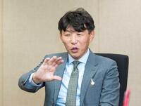 　インタビューに応じるサンデーレーシング・吉田俊介代表＝阪神競馬場（撮影・石湯恒介）