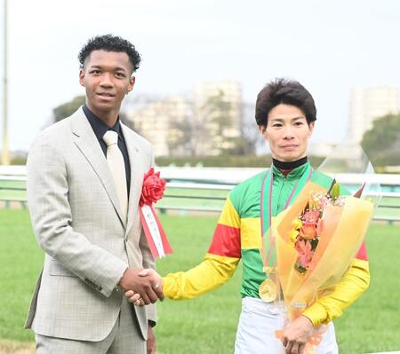 　草野（右）と握手をかわす村竹ラシッド（撮影・園田高夫）