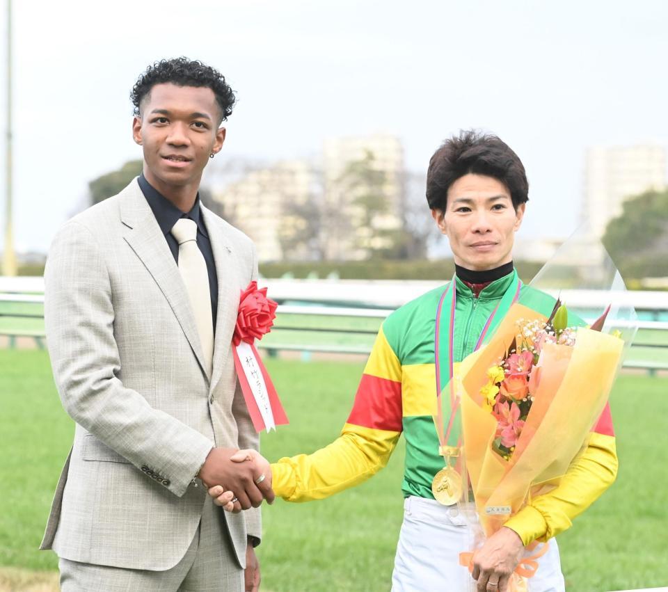 　草野（右）と握手をかわす村竹ラシッド（撮影・園田高夫）