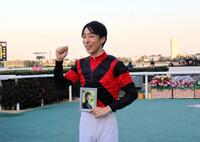 　藤岡康太さんの写真を持つ田中健