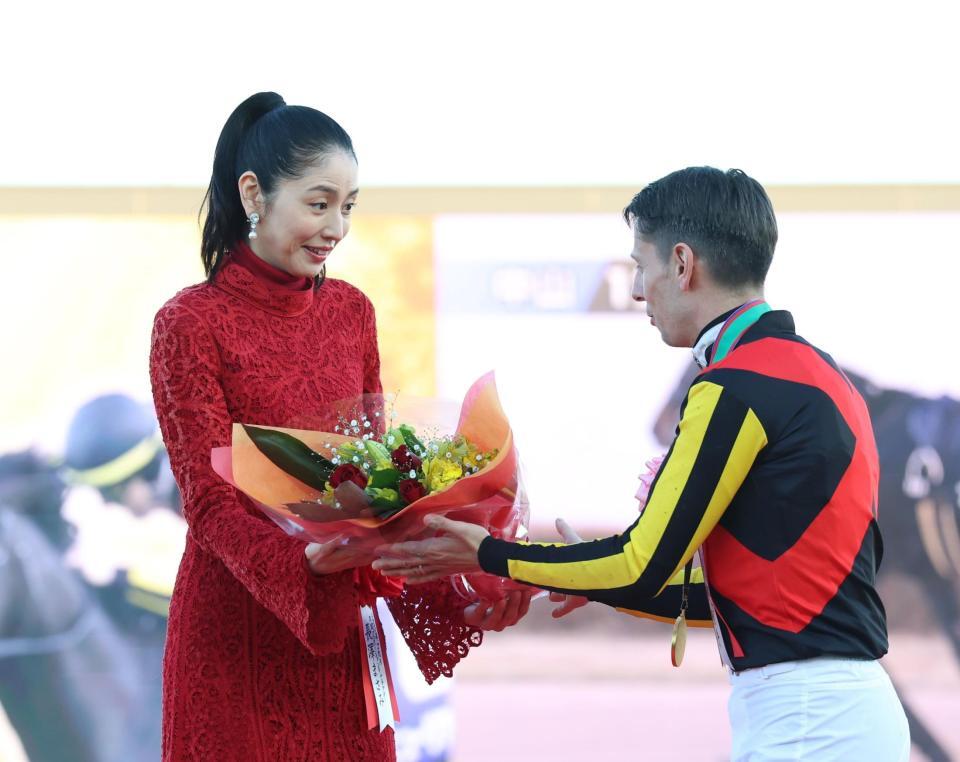 　Ｃ・デムーロ（右）から花束を手渡され戸惑う長澤まさみ（撮影・佐々木彰尚）