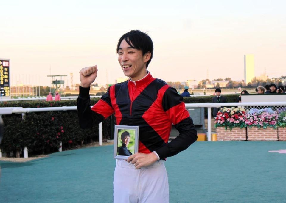 　藤岡康太さんの写真を持つ田中健