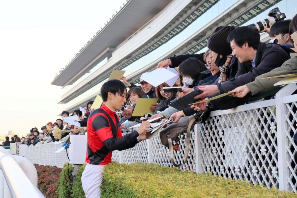 　サインに応じる田中健