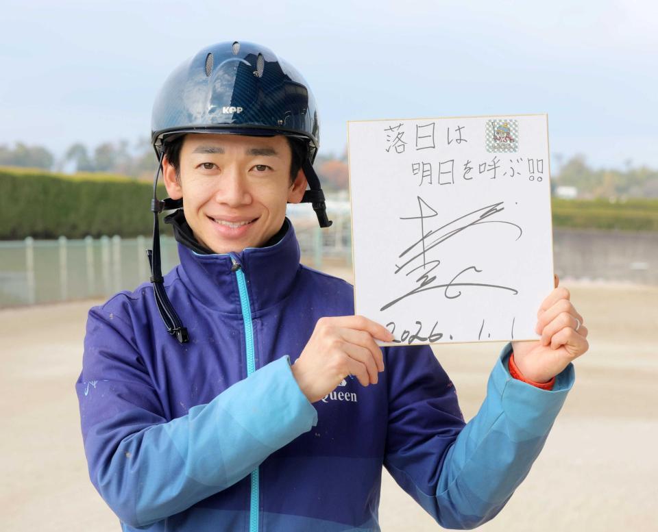 　「落日は明日を呼ぶ！！」としたためた色紙を手にする松山