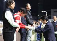 　秋元耕成騎手に商品を授与するデイリースポーツ常務取締役永井英次