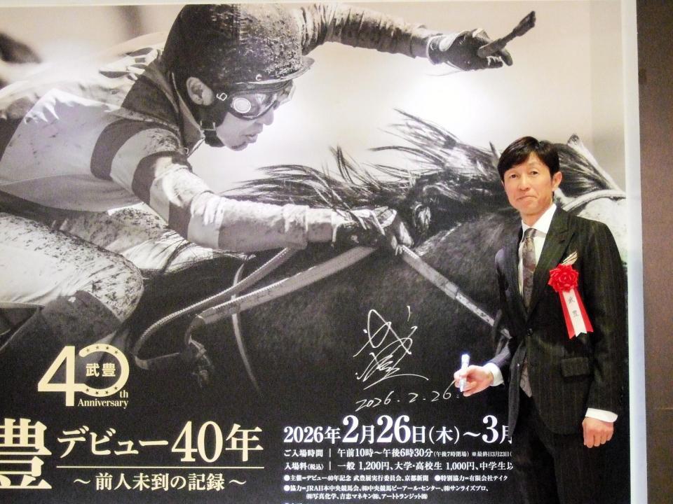 　会場入り口のパネルにサインを入れた武豊