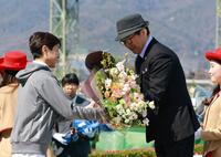 武豊（左）から花束を受け取る佐々木晶三師（撮影・石湯恒介）