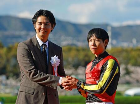 北村友一（右）と握手を交わすプレゼンターの片寄涼太（撮影・石湯恒介）