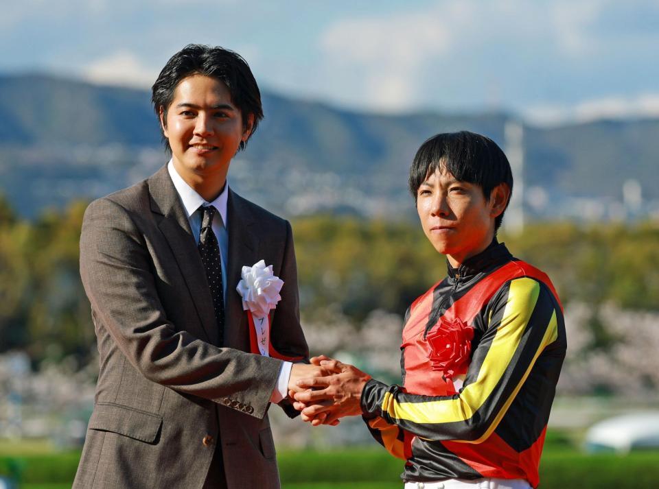 北村友一（右）と握手を交わすプレゼンターの片寄涼太（撮影・石湯恒介）