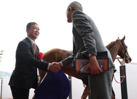 桜花賞をスターアニス（奥）で制し、関係者と握手を交わす高野師（左）＝撮影・中田匡峻