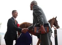 桜花賞をスターアニス（奥）で制し、関係者と握手を交わす高野師（左）＝撮影・中田匡峻