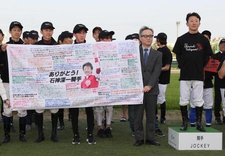 ファンからのメッセージが書かれた横断幕を贈られた石神深一（中央）