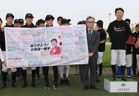 ファンからのメッセージが書かれた横断幕を贈られた石神深一（中央）