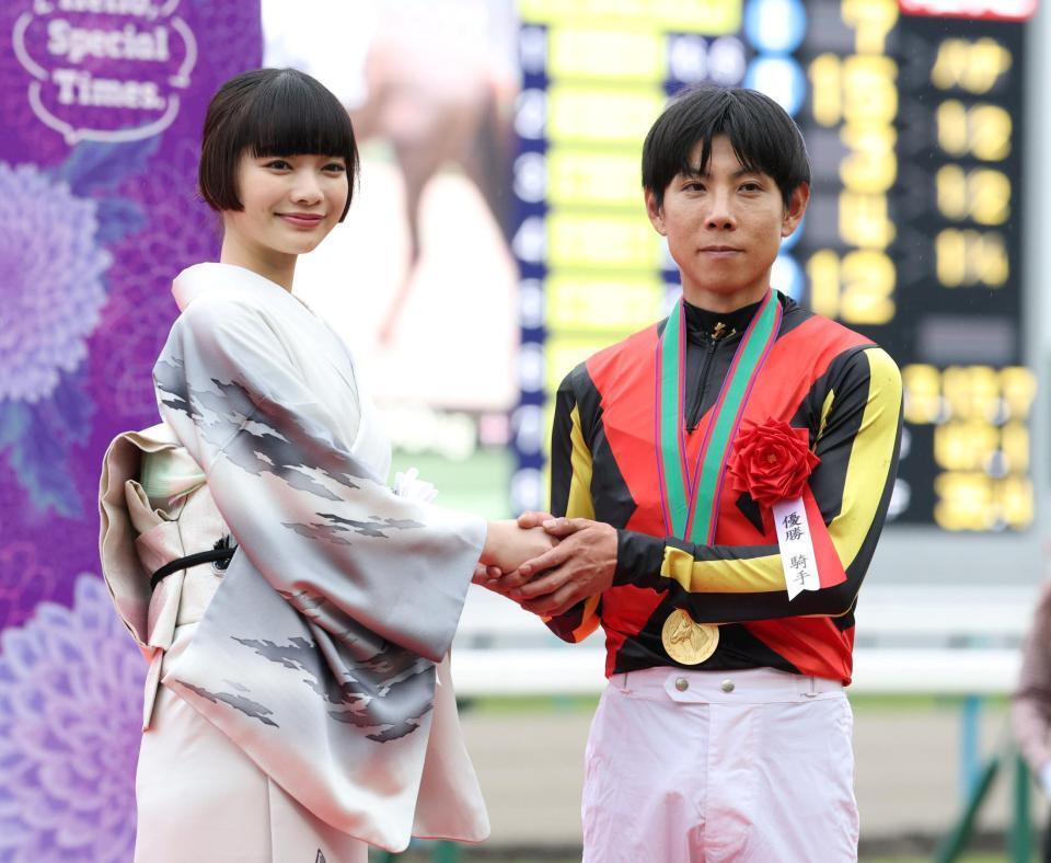 １１Ｒ、クロデュノールで天皇賞を制した北村友一（右）と握手を交わすプレゼンターの見上愛＝撮影・中田匡峻
