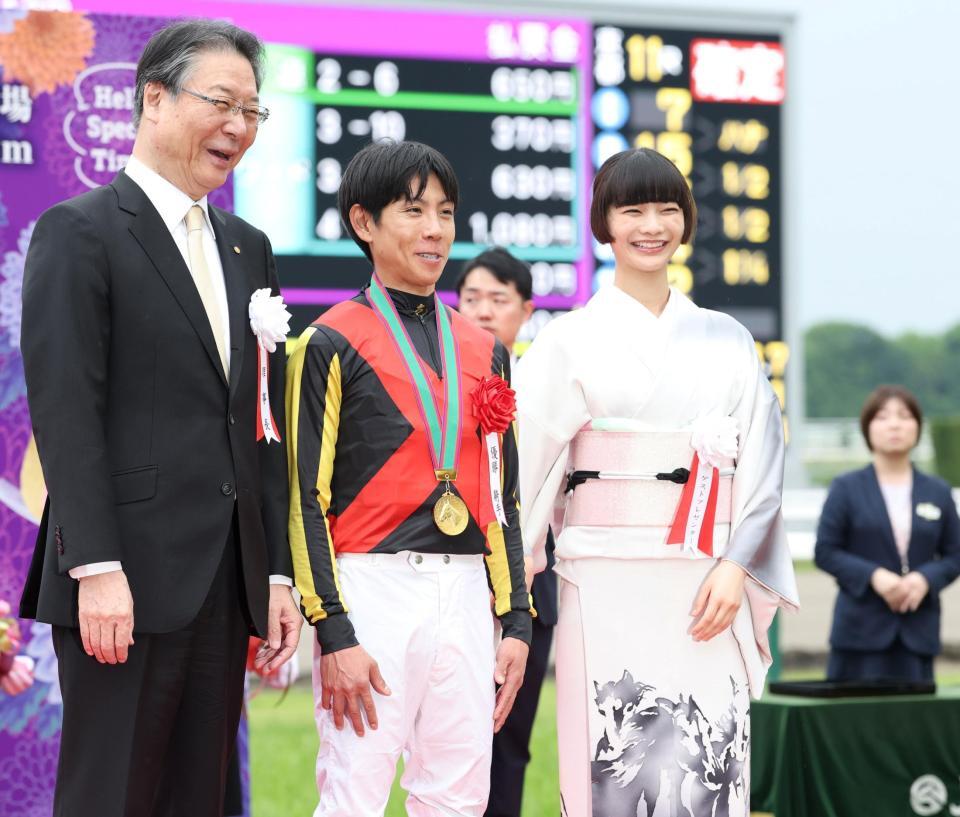 １１Ｒ、クロデュノールで天皇賞を制した北村友一（中央）らと写真に納まる見上愛（右）＝撮影・中田匡峻