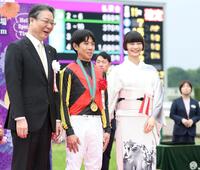 １１Ｒ、クロデュノールで天皇賞を制した北村友一（中央）らと写真に納まる見上愛（右）＝撮影・中田匡峻