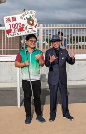 プラカードを持つ弟でバレットの光司さん（左）と喜びのツーショット