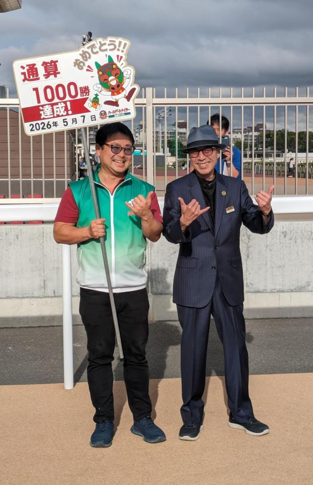 プラカードを持つ弟でバレットの光司さん（左）と喜びのツーショット