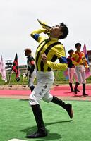 ダービー騎乗ジョッキー紹介でスタンドに花束を投げ込む横山武（撮影・持木克友）