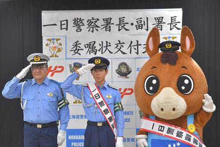 敬礼する（左から）佐藤伸治署長、北村友一、ＳＴＶマスコットのどさんこくん