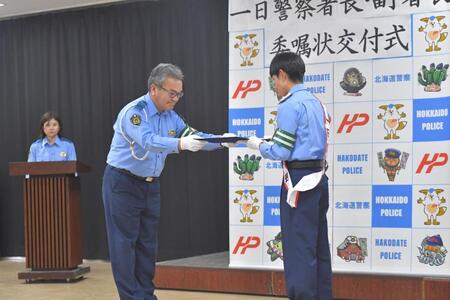 佐藤伸治署長（左）から委任状を受け取る北村友一