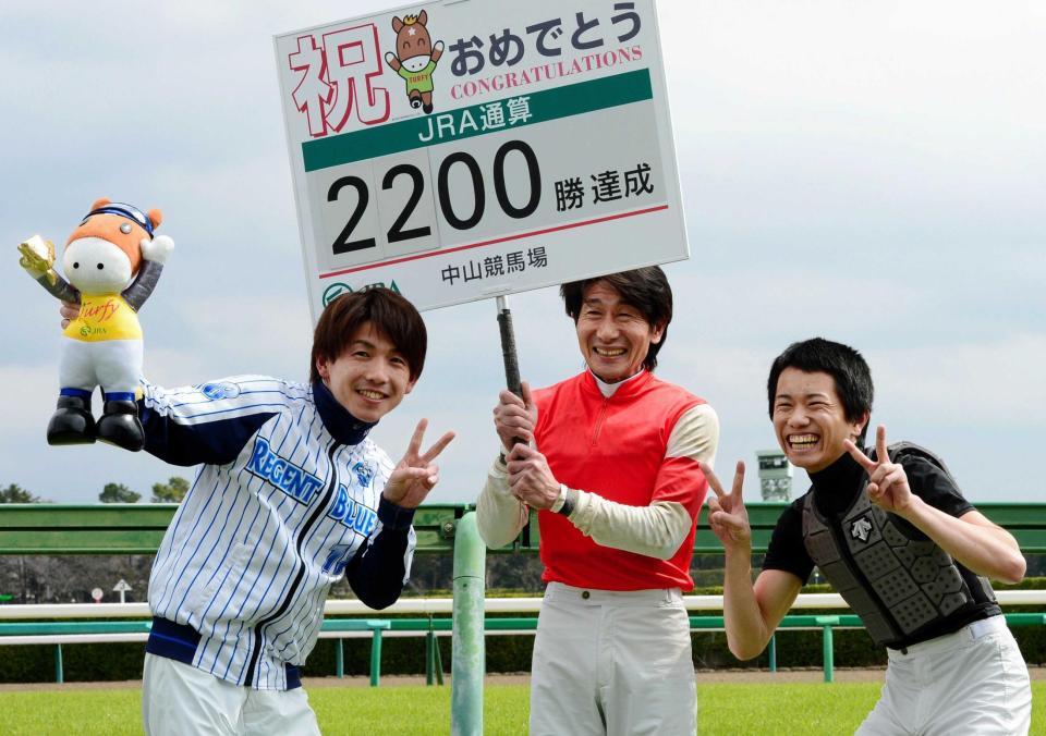 ３Ｒ、ＪＲＡ通算２２００勝を達成し自らプラカードを持って祝う柴田善臣（中央）左は松岡、右は井上＝２０１６年３月
