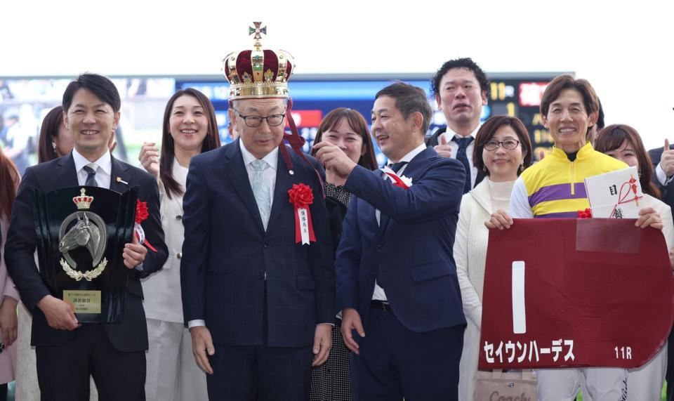 セイウンハーデスで毎日王冠を勝利し、王冠をかぶる西山茂行オーナー（左手前から３人目）。左端は橋口慎調教師、右端は幸