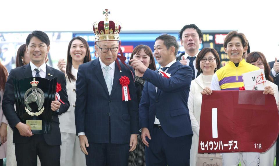 　王冠をかぶる西山茂行オーナー。左は橋口師、右は幸