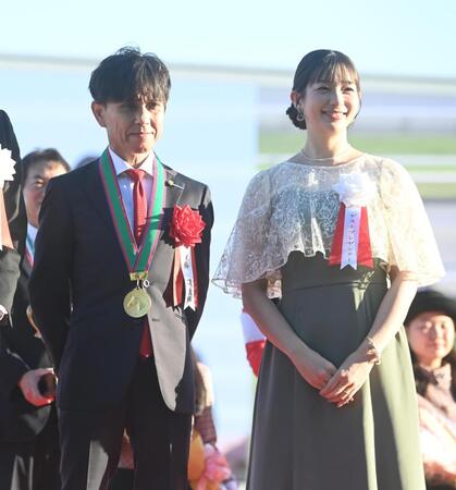 モンローウォークで秋華賞を制し、プレゼンターの足立梨花（右）と記念撮影する上村洋行調教師