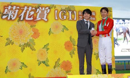プレゼンターの風間俊介（左）と握手を交わす武豊（撮影・石湯恒介）