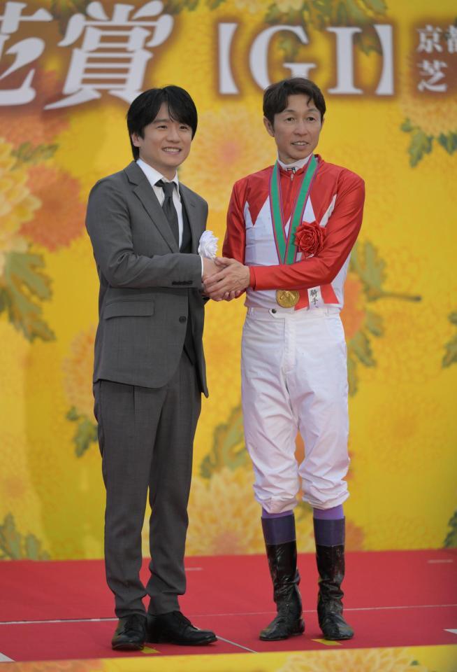記念写真に納まる武豊と風間俊介（左）＝撮影・金居みつよし