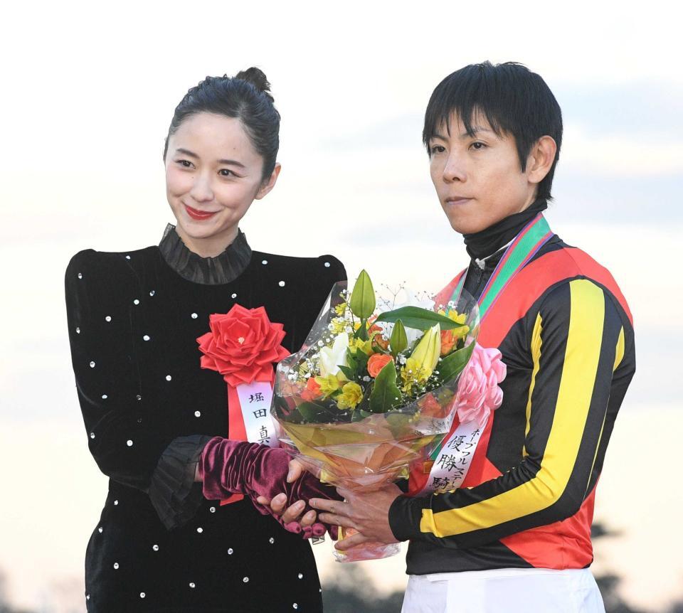 プレゼンターの堀田真由（左）と花束を手にする北村友一